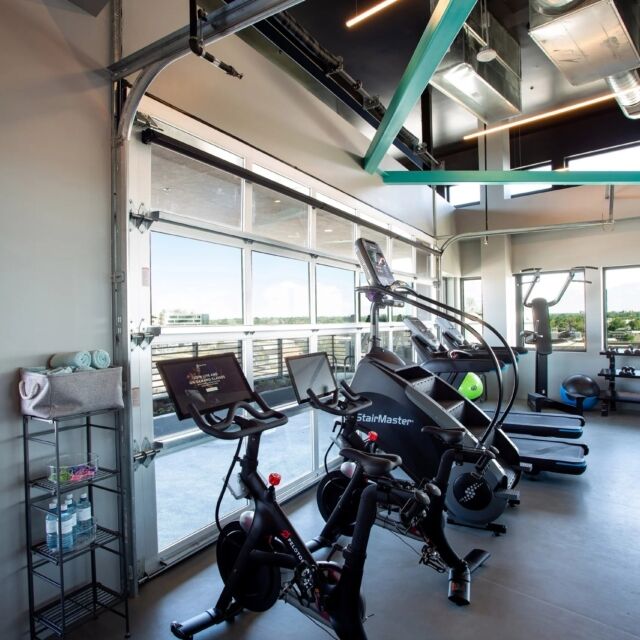 A gym with exercise equipment and windows