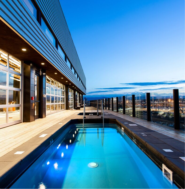 A rooftop pool with a city view at dusk