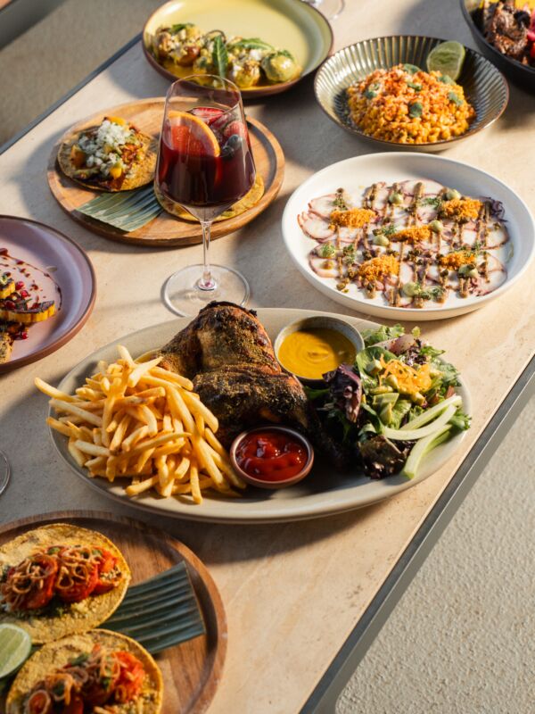A table with various plates of food and glasses.
